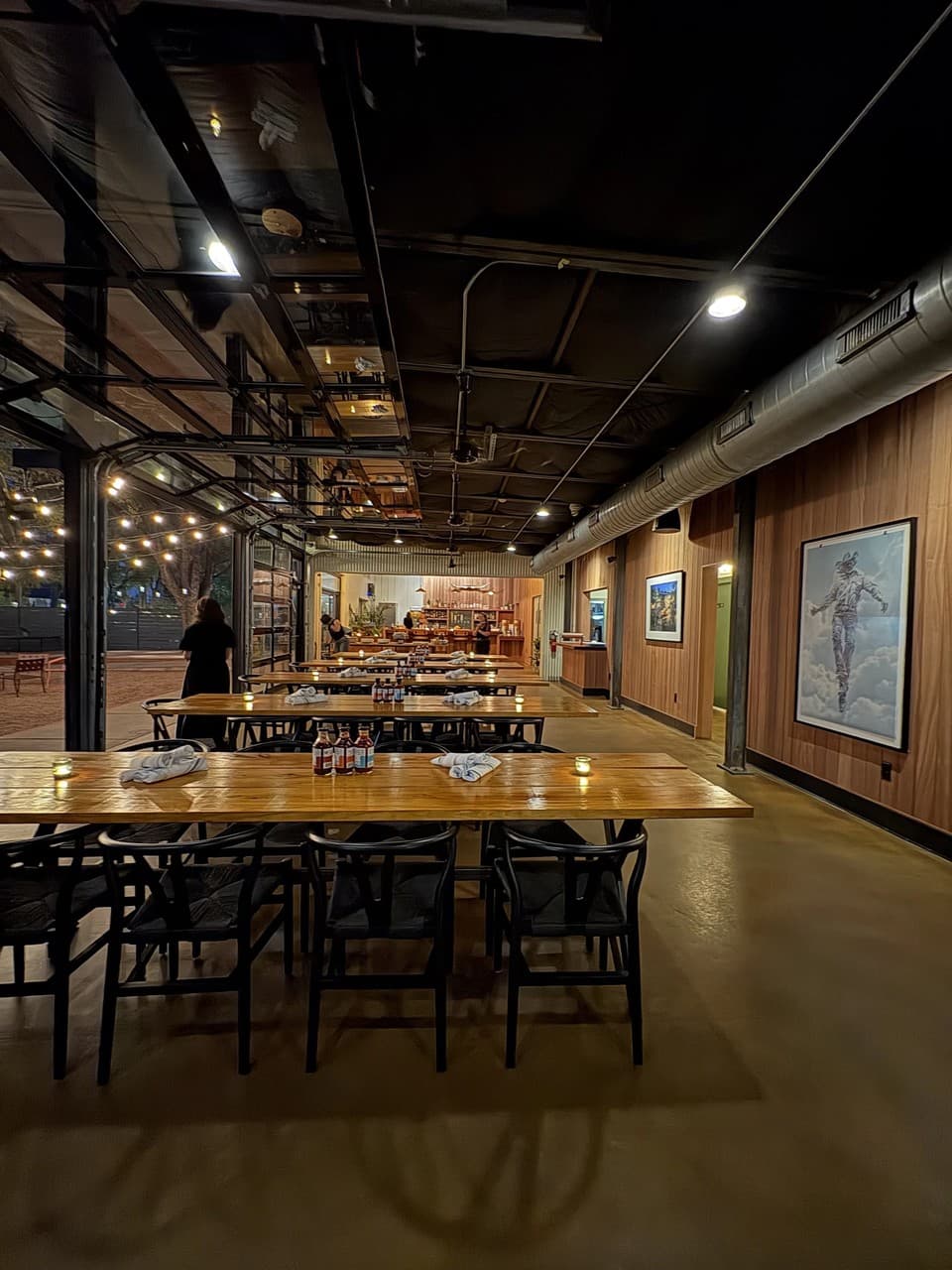 Inside Franklin Barbecue — warm lighting, communal wooden tables, and wood-paneled walls