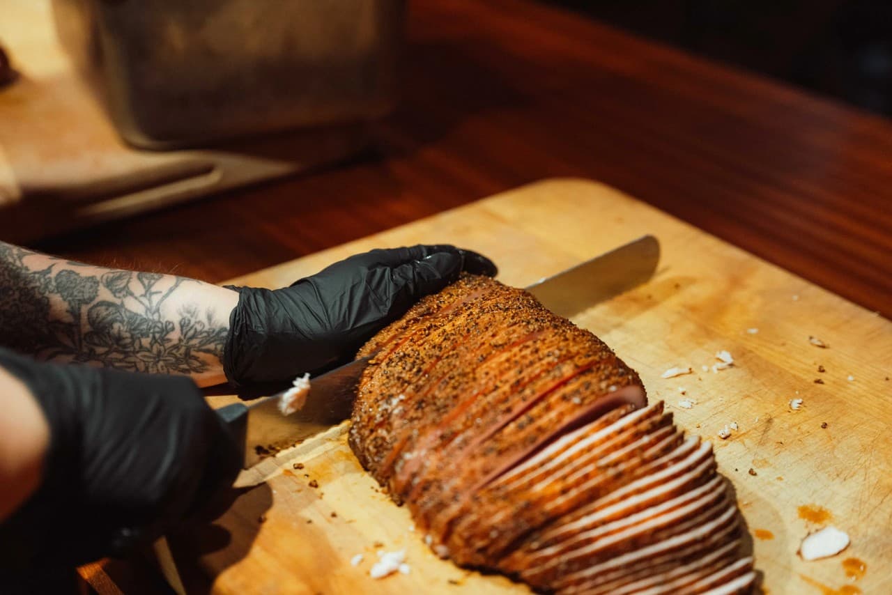 Close-up of hands carefully slicing smoked brisket at Franklin Barbecue