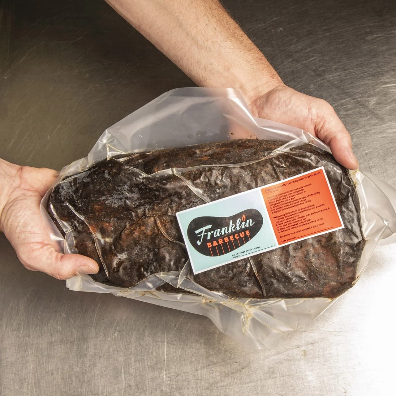 Packaged whole brisket on a stainless steel prep table, ready for shipping